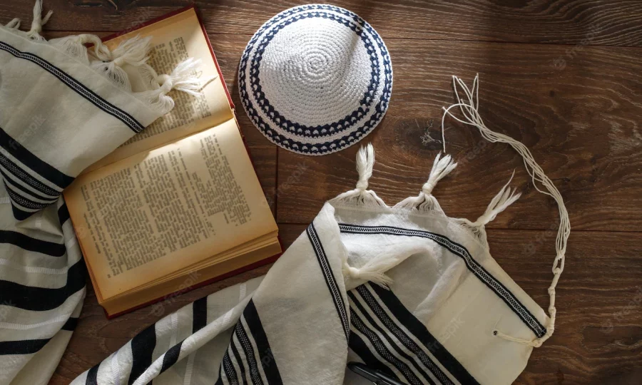 jewish-traditional-prayer-supplies-talite-kippah-torah-wooden-table-shabbatta-bar-mitzvah-yom-kippur-concept_329479-381